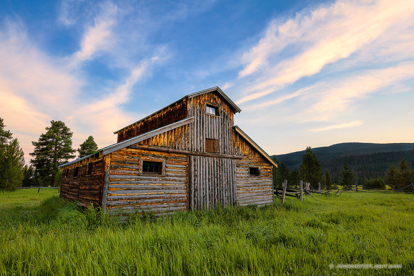 A beautiful wooden barn sits in the Kawuneeche Valley on the western side of Rocky Mountain National Park in Colorado.  Clouds lazily floated by as the sun set behind the Never Summer Range in the distance. - Colorado Picture
