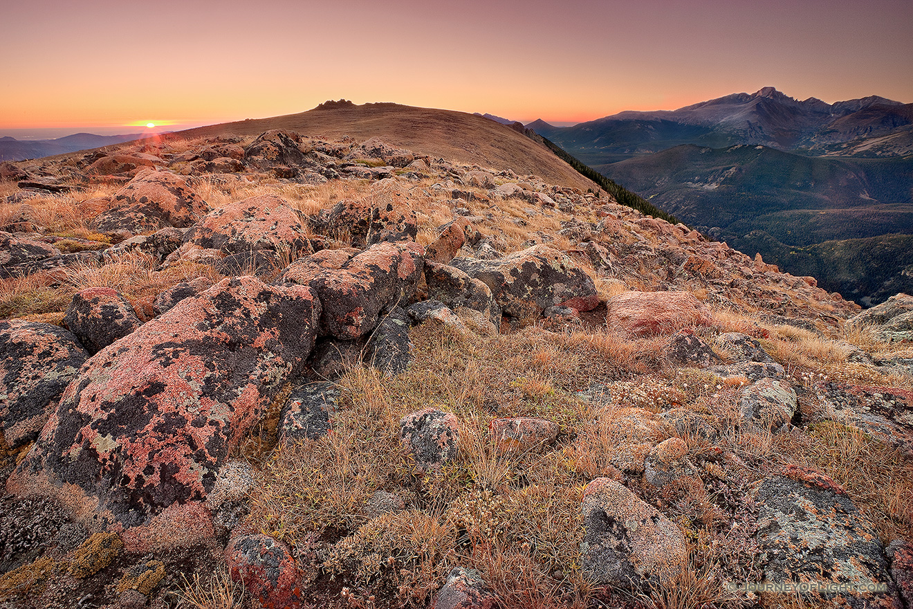 On this day, as many days through time, the exposed rocks on the tundra area of Rocky Mountain National Park bear witness to the rising sun and its illumination of Longs Peak. - Colorado Picture