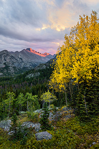After a brief rainfall, on a cool autumn evening the last  bit of sun illuminates the peak of Long's Peak in Rocky Mountain National Park. - Colorado Landscape Photograph
