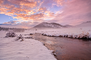 On a cold day in mid-May, the Big Thompson flows through Moraine Park as the first sunlight of the day illuminates clouds to the east. - Colorado Landscape Photograph