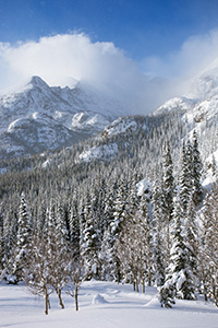 On the trail to Dream Lake, Long's Peak is obscured, encased in blowing snow and clouds in Rocky Mountain National Park, Colorado. - Colorado Photograph