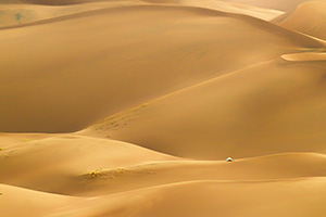 A tent stands on a distant dune in Great Sand Dunes National Park and Preserve in south central Colorado. - Colorado Outdoor Photograph Photograph