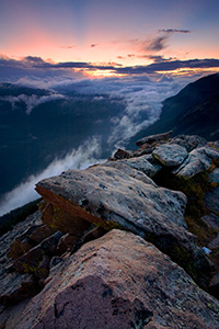 Clouds gather in the valleys of Rocky Mountain National Park as the sun sets in the distance. - Colorado Photograph