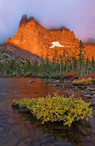 One of my favorite lakes in Rocky Mountain is Lake Helene.  About 2 and a half miles from Bear Lake, this spot is nestled at the bottom of Notchtop Mountain.  On a September day, the leaves on the bushes have turned a bright crimson hue and the early morning fog begins to dissipate quickly as the the mountain glows with the advent of a new dawn.  It is serenity and peacefulness with only the rustling of the trees and the occasional chirp of a Steller�s Jay. - Colorado Photograph
