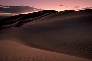 As I photographed this scene, I almost imagined myself in a foreign land as the sun dipped below the horizon.  The shapes of the dunes in this photo become abstract lines and patterns in the late dusk light. - Rockies Photograph