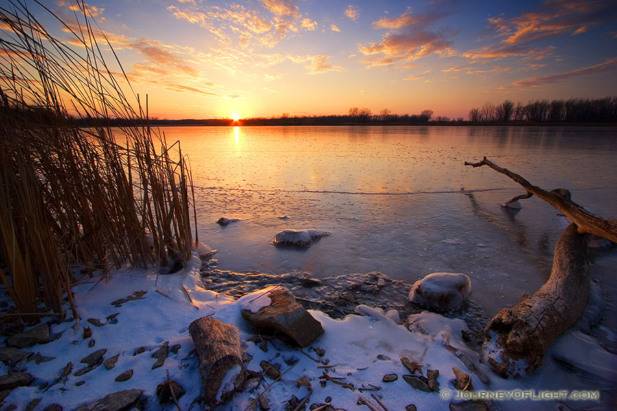 The sun reflects off a frozen lake in DeSoto National Wildlife Refuge in eastern Nebraska. - DeSoto Photography