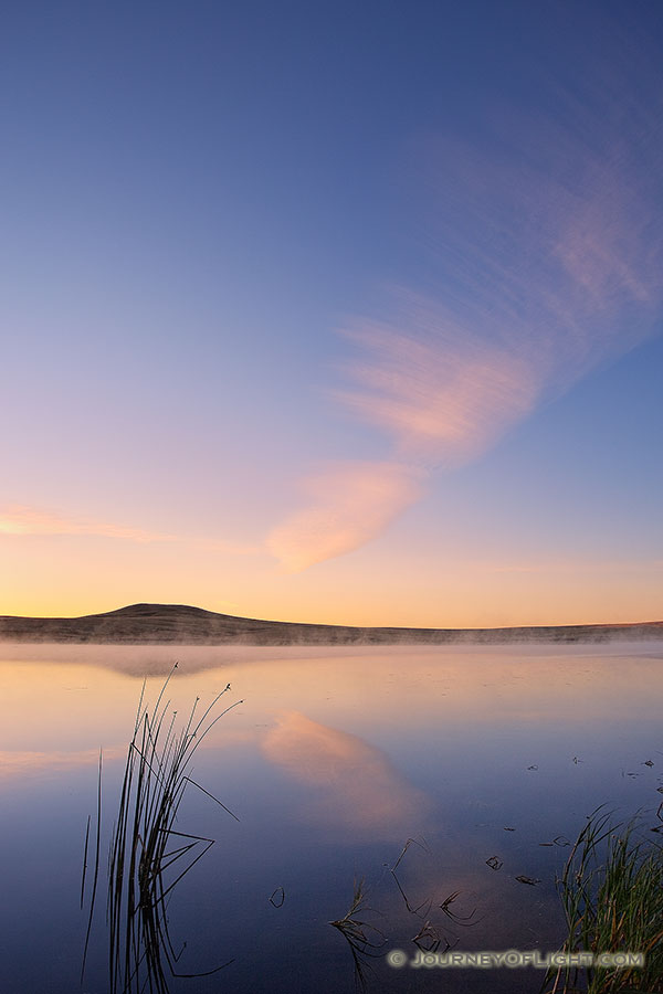 On a cool autumn morning, mist rises from Meng Reservoir on the Oglala Grassland while a single clouds hovers over the lake. - Nebraska Photography