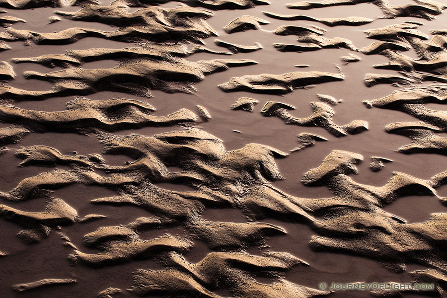 Capturing a photograph of a nature abstract, sand and water collide and intermingle to create interesting patterns along the banks of the Platte River in Eastern Nebraska. - Nebraska Photography