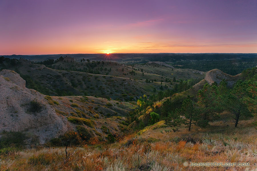 On an early fall morning, the rising sun shines brightly across Chadron State Park, in western Nebraska. - Nebraska Photography