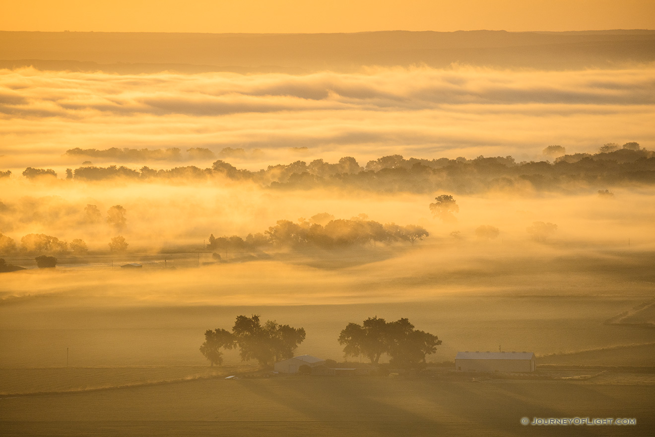 A scenic landscape photograph of the first sunrise light illluminating the fog across the Nebraska plains. - Nebraska Picture