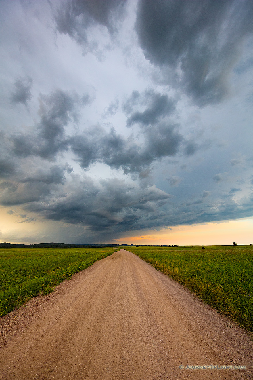 A landscape photograph of an intense summer storm rages over a rural country road in South Dakota. - South Dakota Picture