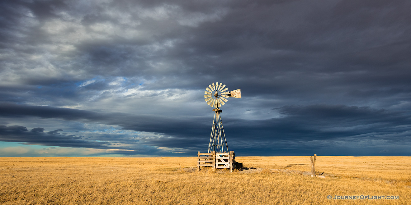 Scenic landscape panoramic photograph of a windmill and a storm at Oglala National Grasslands. - Nebraska Picture