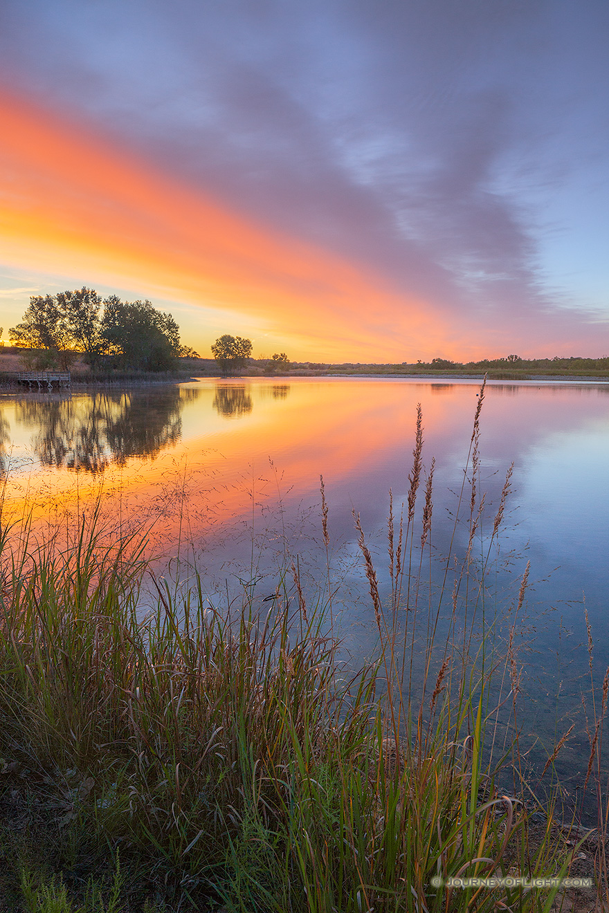 A landscape photograph of a sunrise reflected in a lake at Mahoney State Park, Nebraska. - Nebraska Picture