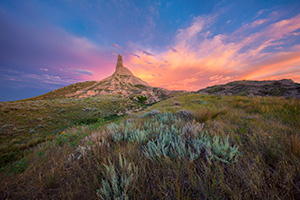 A scenic landscape photograph of a sunset and Chimney Rock National Historic Site. - Nebraska Photograph