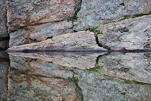 An abstract photograph of rocks reflected in Sylvan Lake in Custer State Park, South Dakota. - South Dakota Photograph