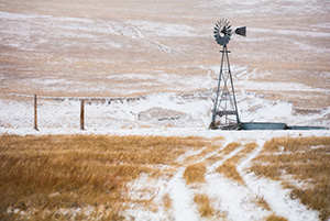Scenic landscape panoramic photograph of a windmill and a road in the winter at Oglala National Grasslands. - Nebraska Photograph