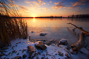 The sun reflects off a frozen lake in DeSoto National Wildlife Refuge in eastern Nebraska. - Nebraska Photograph