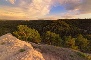 In the extreme Northwestern edge of Nebraska, north of Harrison is a little WMA called Gilbert-Baker WMA.  On this cool spring evening, I hiked for a couple of miles over a few hills and then sat on this rock content to eat my dinner and watch a storm brew in the distance and then dissipate, leaving interesting clouds to reflect the light of the setting sun. - Nebraska Landscape Photograph