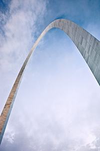 Built between February 12, 1963, and October 28, 1965 the Gateway Arch in St. Louis was designed to honor the westward expansion of the United States.  Designed by architect Eero Saarinen and engineer Hannskarl Bandel, it is 630 feet wide at its base and 630 feet tall and is currently the tallest monument in the United States.  From the base of the north leg looking in a south easterly directly, the structure curves through the sky almost touching the low clouds.  - Missouri Photograph
