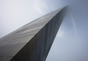 From the base of the north leg looking in a south easterly directly, the Gateway Arch curves through the sky and into the fog.  - Missouri Photograph