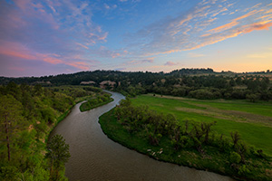 The Niobrara river west of Niobrara National Wildlife Refuge, snakes through a lush green valley on a beautiful spring morning. A cool breeze blew gently as the sun rose in the east illuminating the clouds in the sky. - Nebraska Photograph