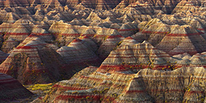 A section of the Badlands in South Dakota glow with the warmth of the pre-risen sun. - South Dakota Photograph