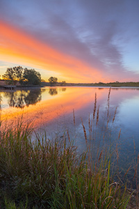 A landscape photograph of a sunrise reflected in a lake at Mahoney State Park, Nebraska. - Nebraska Photograph