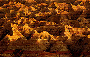 The late afternoon sun creates abstract shapes from the long shadows in the Badlands, South Dakota. - South Dakota Photograph