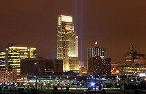 On September 11, 2006 Omaha, Nebraska paid tribute to the victims of 9/11 by hanging 2 large United States flags on the Woodmen tower and by shining two large lights into the sky. - Nebraska Photograph