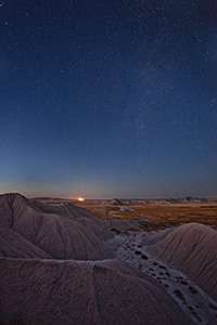 Stars fill the night sky while a train waits on the horizon at Toadstool Geologic Park near Chadron in western Nebraska. - Nebraska Photograph
