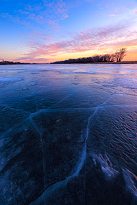 A scenic landscape photograph of the sunset over the frozen lake at DeSoto NWR, Nebraska. - Nebraska Photograph