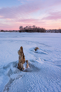 A scenic landscape photograph of purple clouds over the frozen lake at Walnut Creek, Nebraska. - Nebraska Photograph